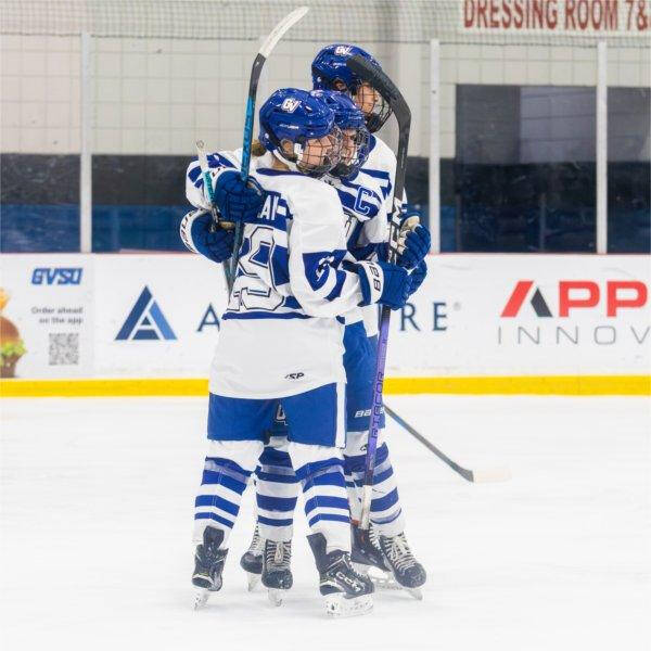 Women's Club Hockey players hugging while on the ice